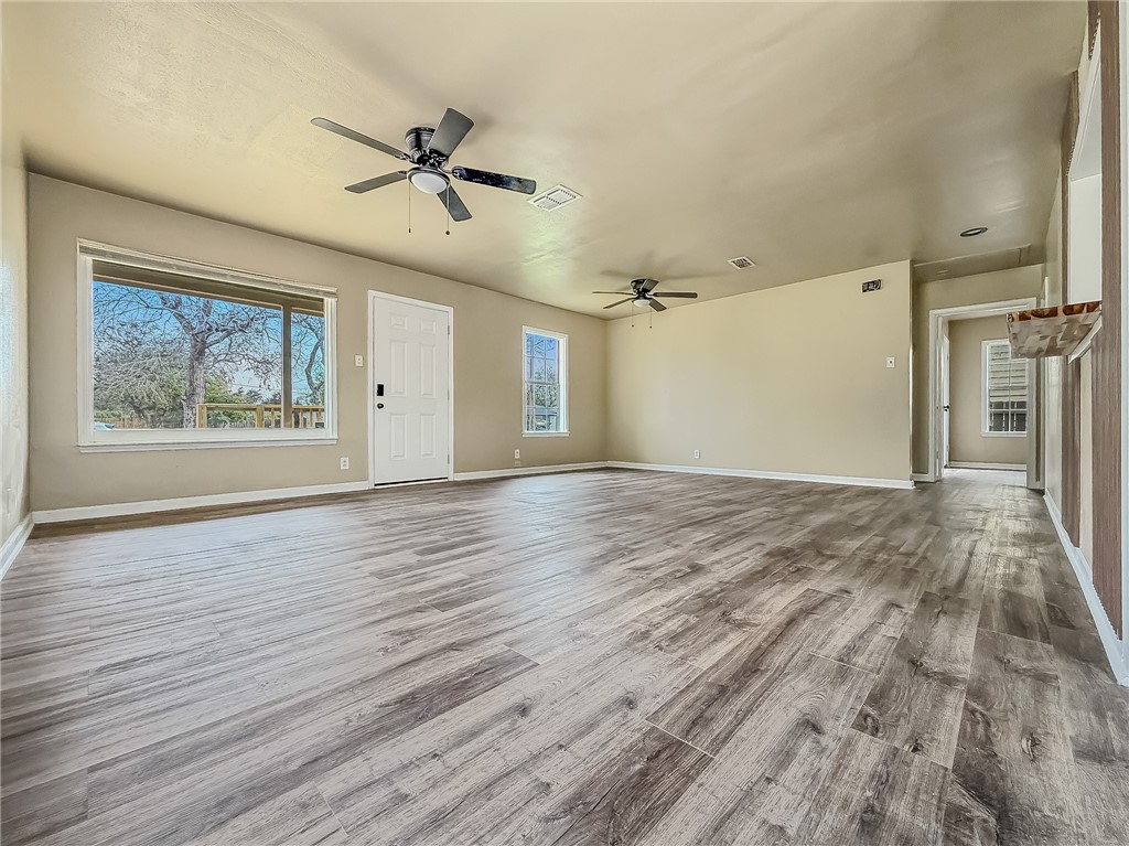 3437 Austin Street Corpus Christi, TX 78411 - Photo 8 of 35 an empty room with wooden floor ceiling fan and windows