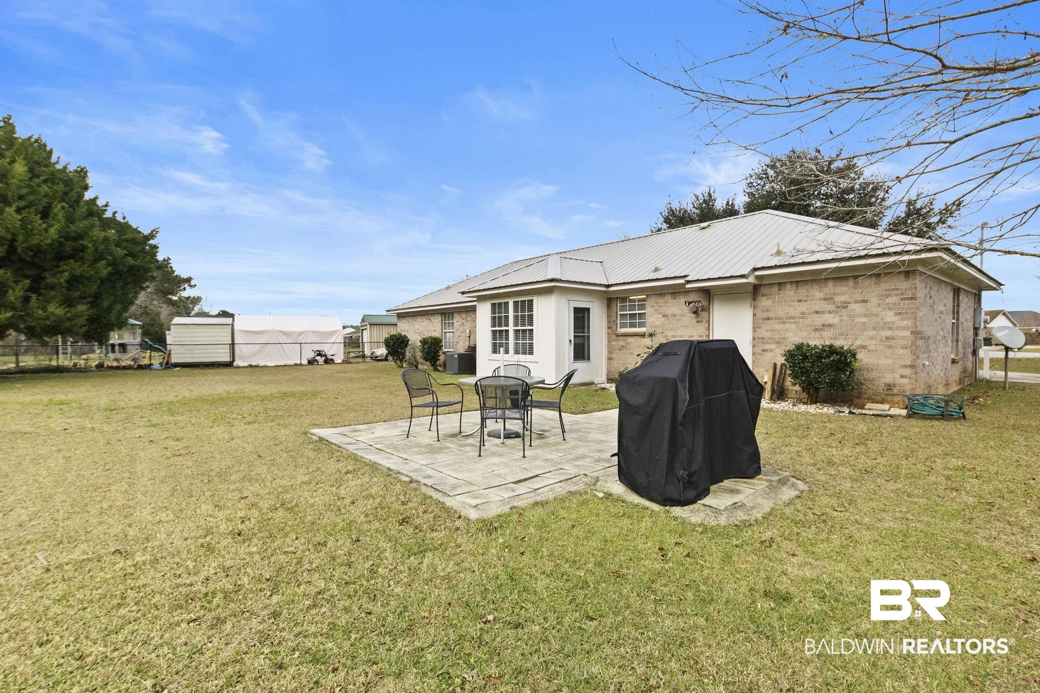 14031 Brook Hollow Road Summerdale, AL 36580 - Photo 55 of 56 Rear view of property featuring a patio area and a yard