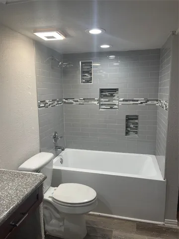 a bathroom with a granite countertop sink toilet and bathtub