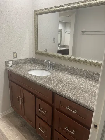 a bathroom with a granite countertop sink and a mirror