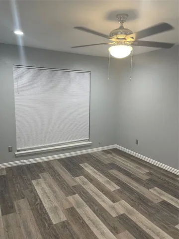 a view of an empty room with a chandelier fan