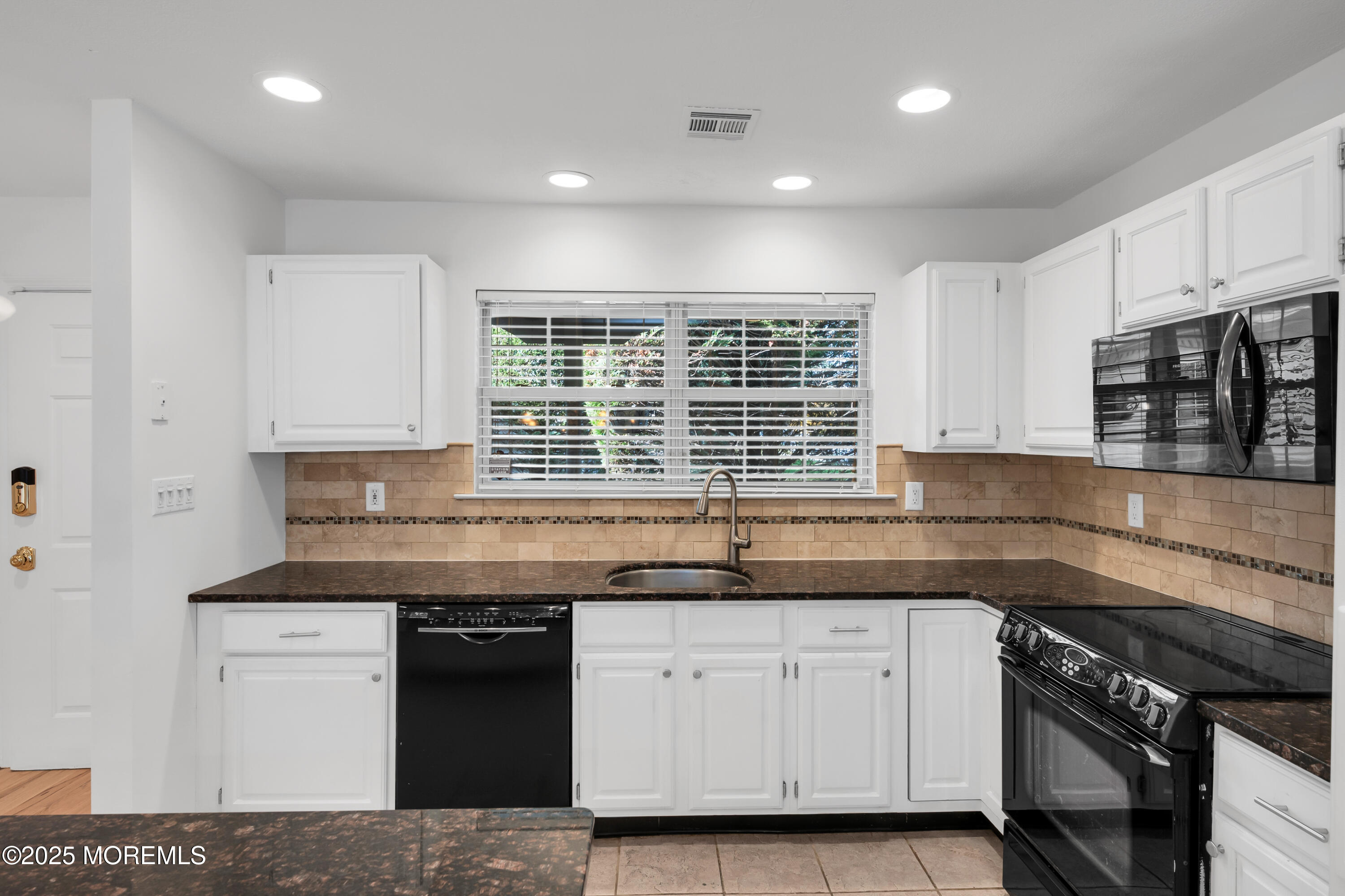 9 Ambrose Lane, Unit 141 Holmdel, NJ 07733 - Photo 14 of 50 a kitchen with granite countertop a stove sink and cabinets