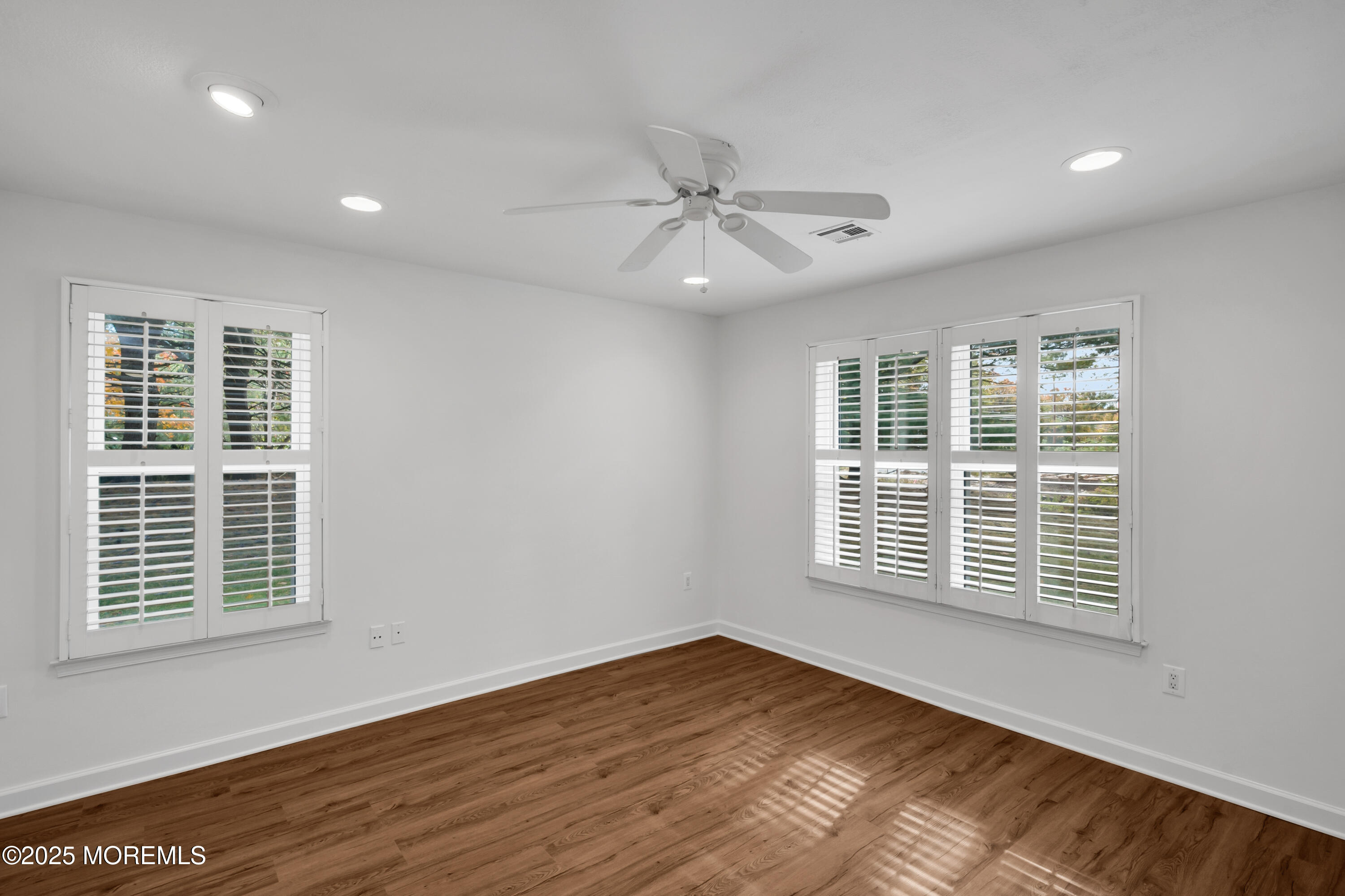 9 Ambrose Lane, Unit 141 Holmdel, NJ 07733 - Photo 25 of 50 a view of an empty room with wooden floor and a window