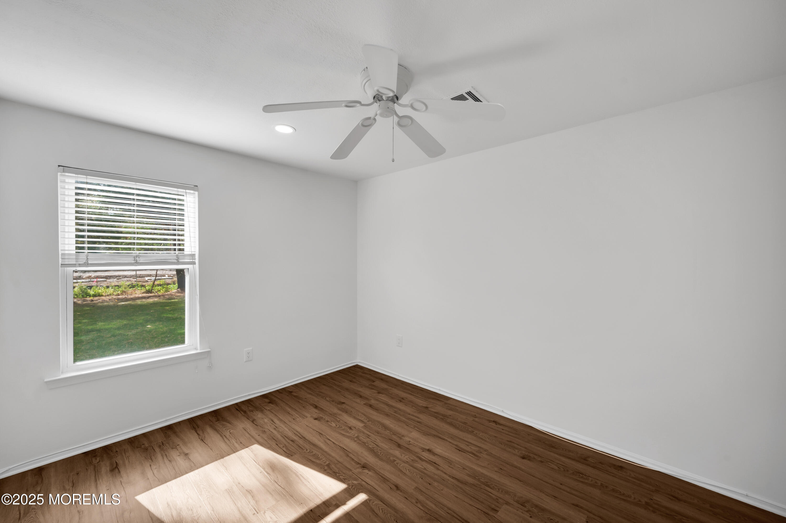 9 Ambrose Lane, Unit 141 Holmdel, NJ 07733 - Photo 31 of 50 an empty room with wooden floor fan and windows