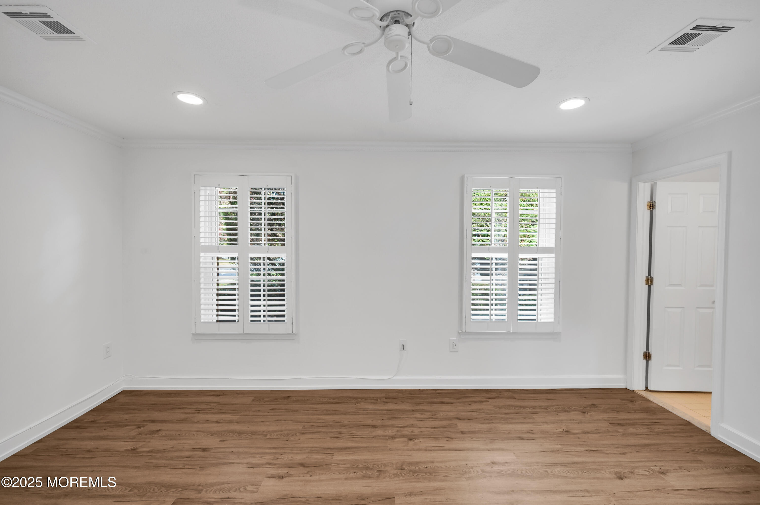 9 Ambrose Lane, Unit 141 Holmdel, NJ 07733 - Photo 37 of 50 a view of an empty room with wooden floor and a window