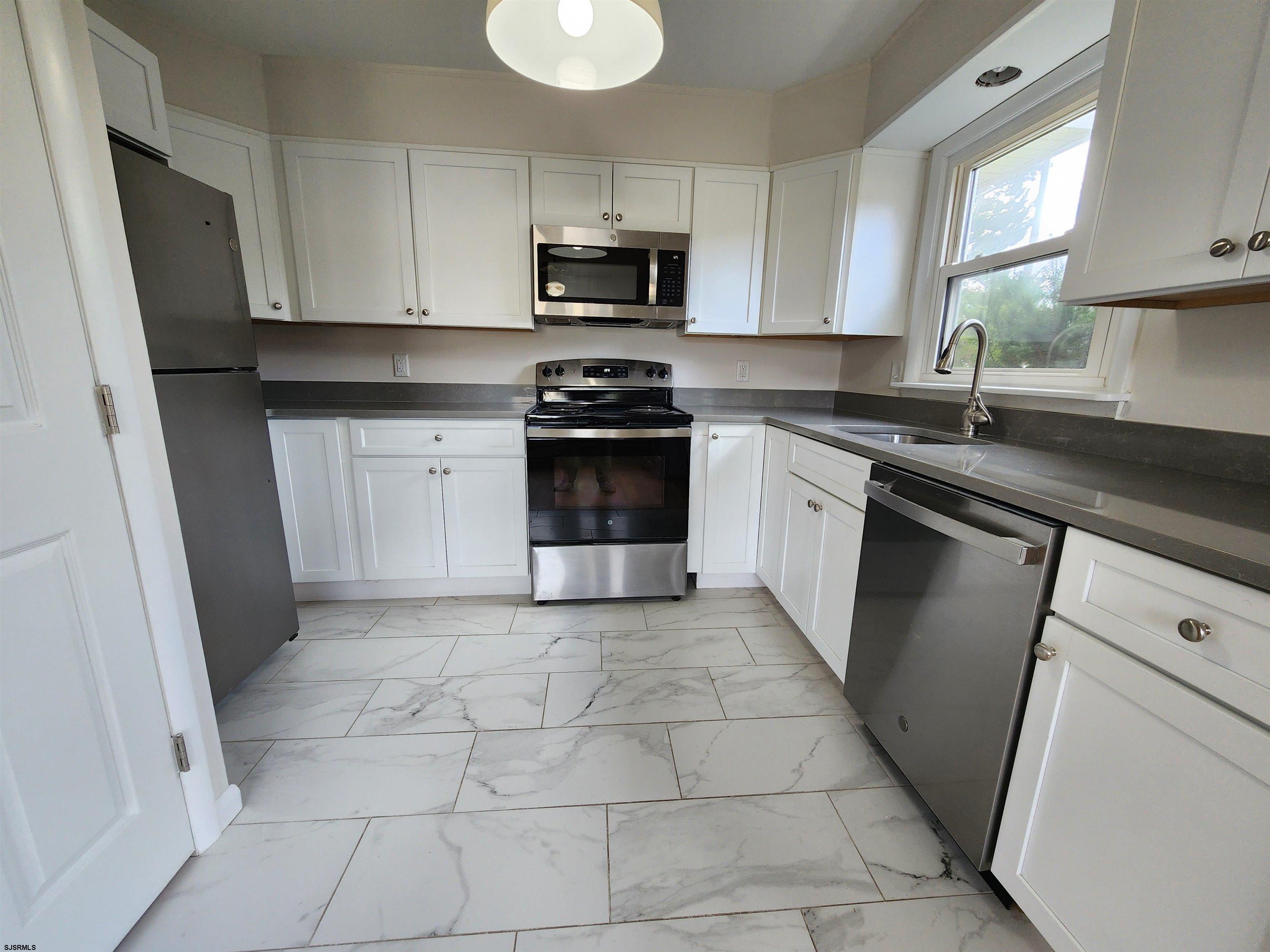 10 Point Pleasant Avenue Beesleys Point, NJ 08223 - Photo 3 of 16 a kitchen with a stove a sink and a microwave
