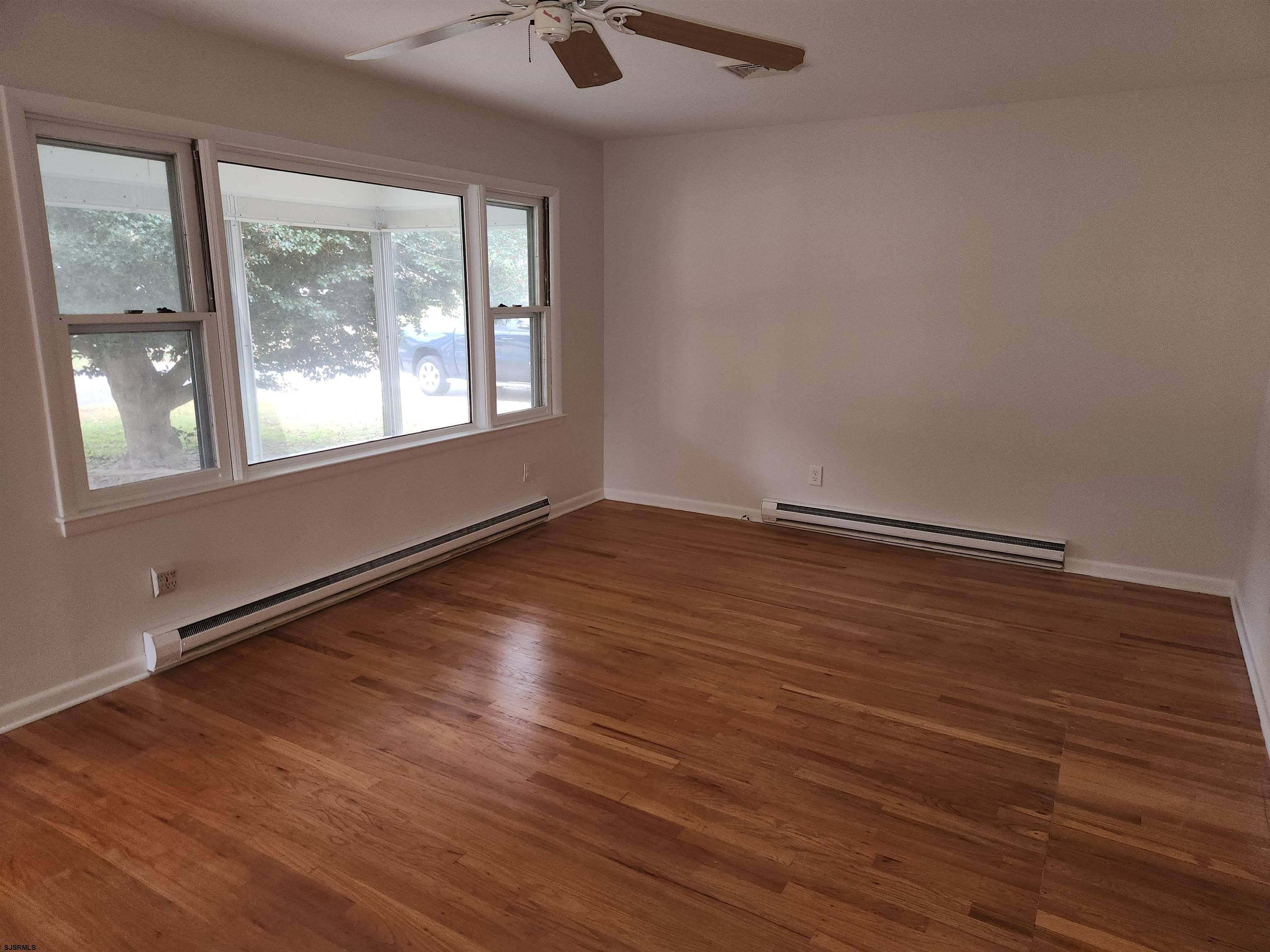 10 Point Pleasant Avenue Beesleys Point, NJ 08223 - Photo 5 of 16 an empty room with wooden floor and windows