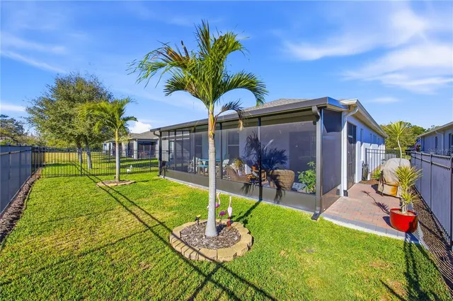 a room with lots of furniture a large window and potted plant