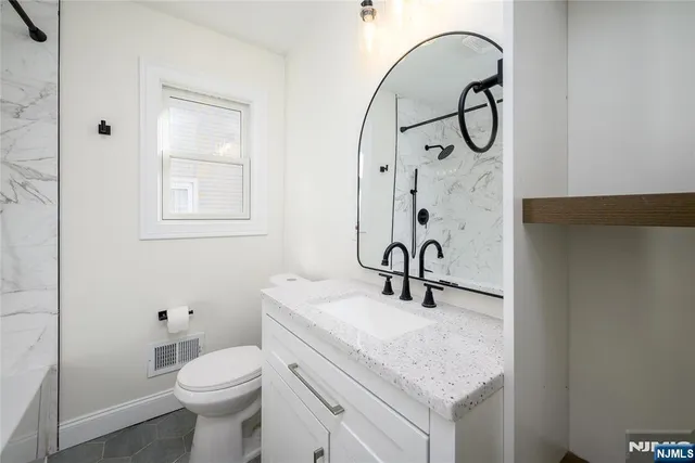 a bathroom with a sink a toilet and a mirror