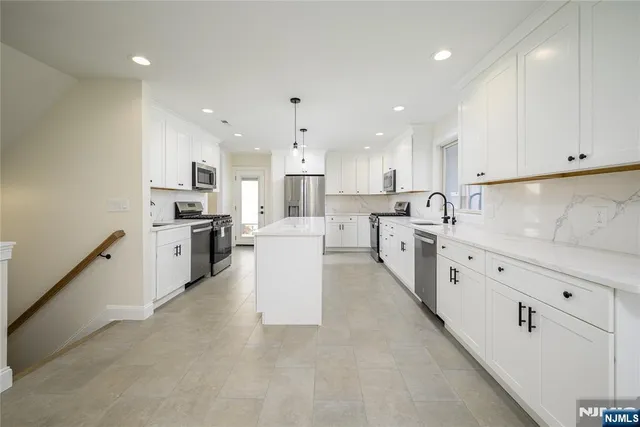 a large white kitchen with cabinets and stainless steel appliances