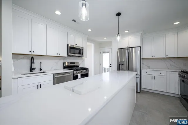 a kitchen with white cabinets and stainless steel appliances
