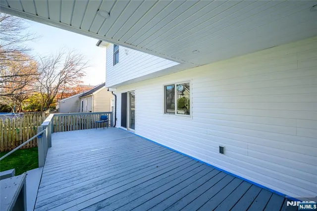 a view of backyard with wooden deck and trees