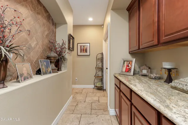 a kitchen with granite countertop a sink a stove and cabinets