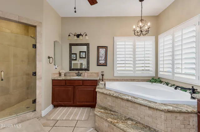 a spacious bathroom with a granite countertop tub sink and mirror