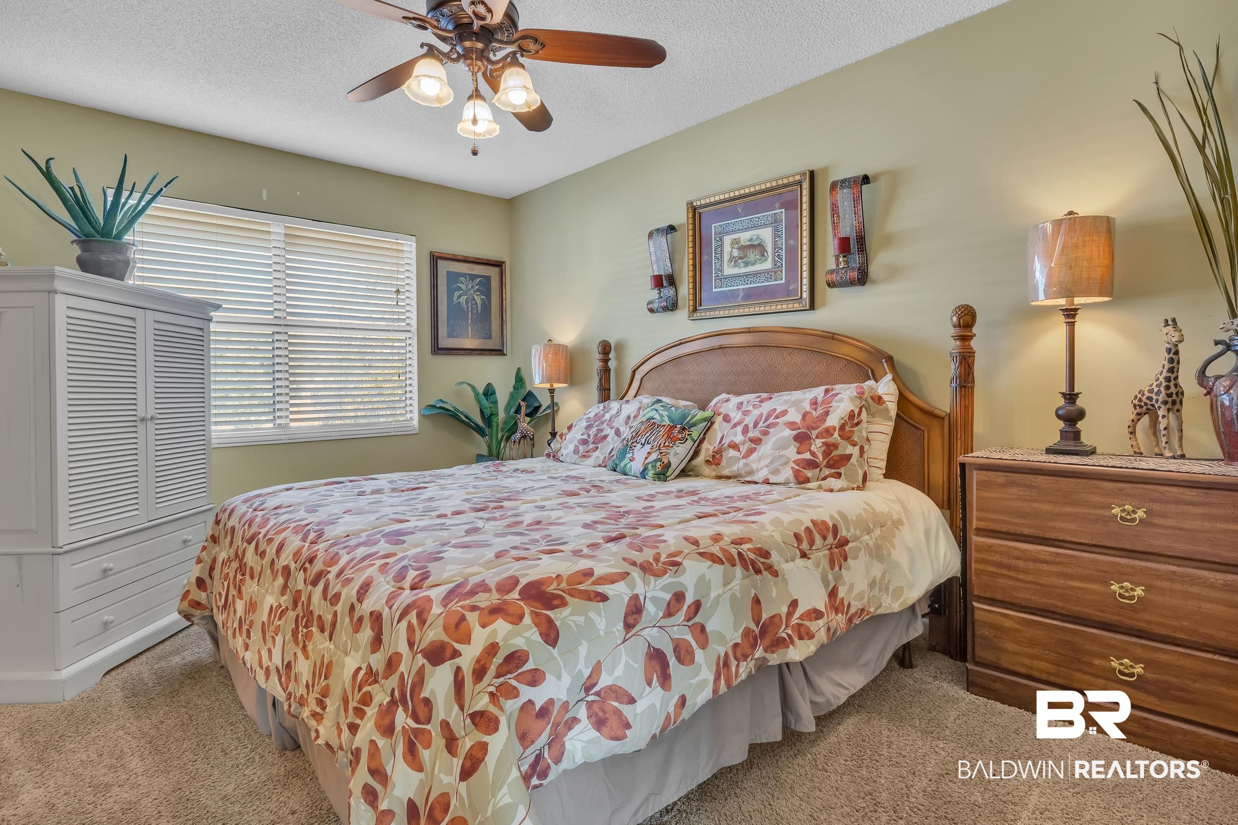 3256 Loop Road, Unit 2 Orange Beach, AL 36561 - Photo 22 of 25 Carpeted room featuring a ceiling fan with integrated lighting, a window with horizontal blinds, a large built-in wardrobe with louvered doors and drawer storage, and a built-in wooden headboard