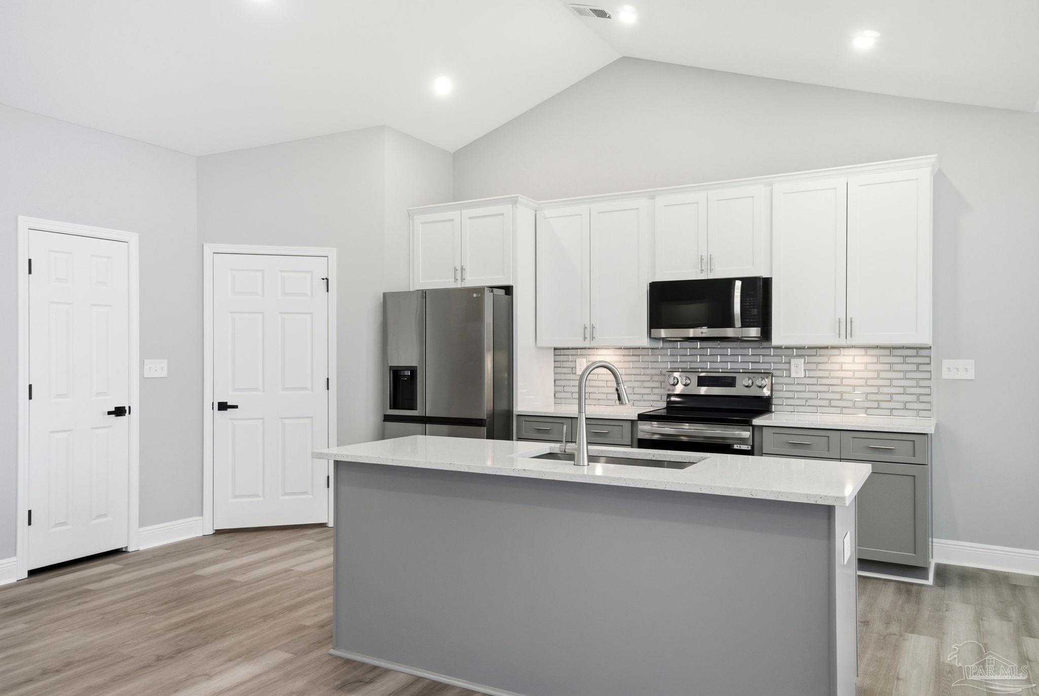 5712 Riviera Drive Milton, FL 32583 - Photo 14 of 41 a kitchen with stainless steel appliances a microwave a sink and a refrigerator