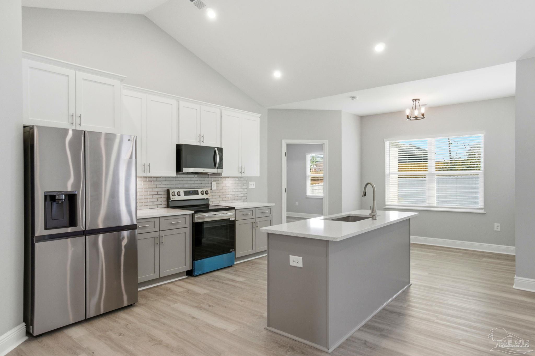 5712 Riviera Drive Milton, FL 32583 - Photo 15 of 41 a kitchen with stainless steel appliances granite countertop a refrigerator a stove top oven a sink and dishwasher