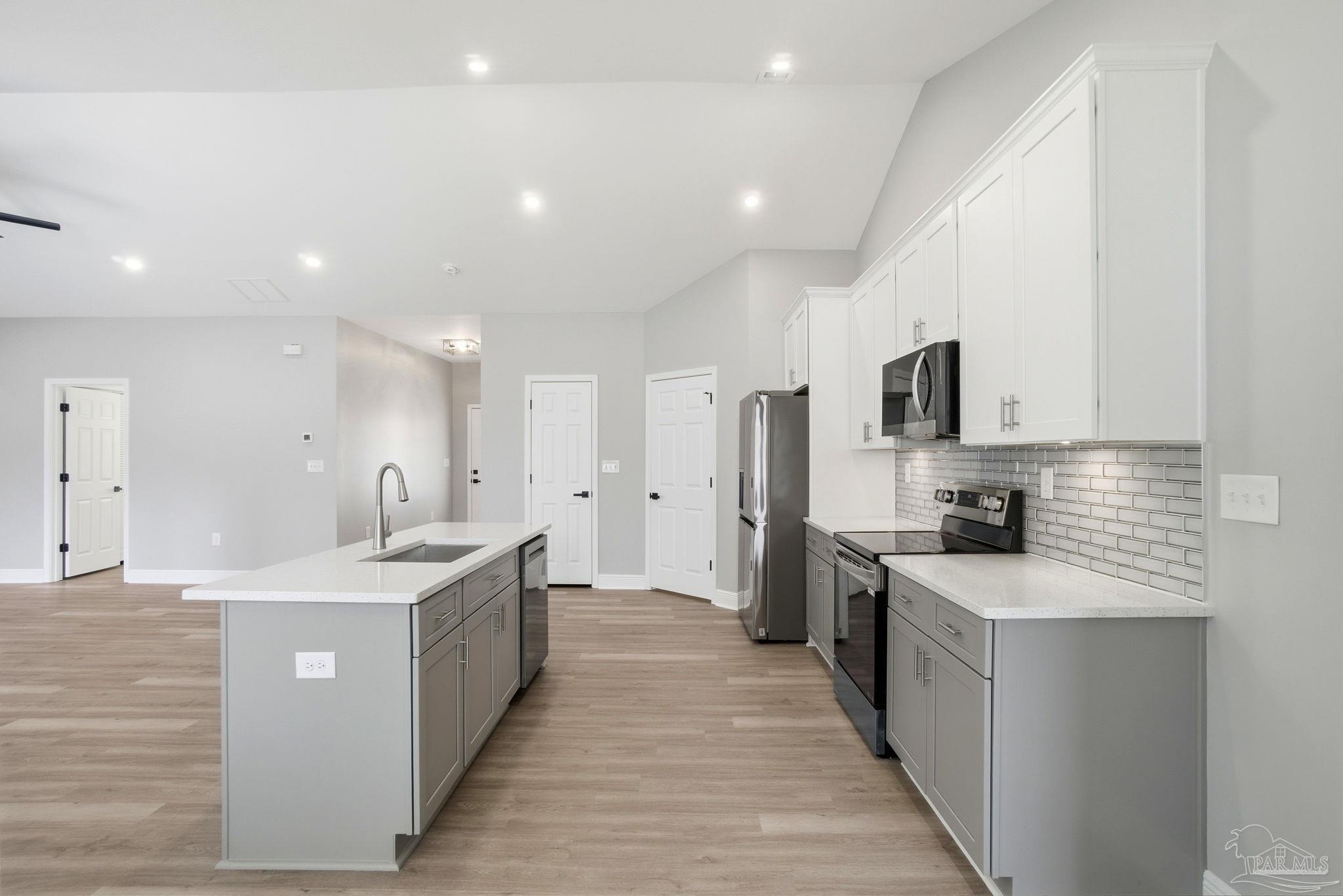 5712 Riviera Drive Milton, FL 32583 - Photo 17 of 41 a large kitchen with stainless steel appliances lots of counter space and wooden floor