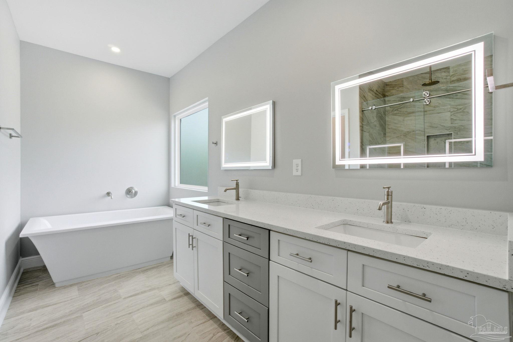 5712 Riviera Drive Milton, FL 32583 - Photo 24 of 41 a bathroom with a double vanity sink mirror and bathtub