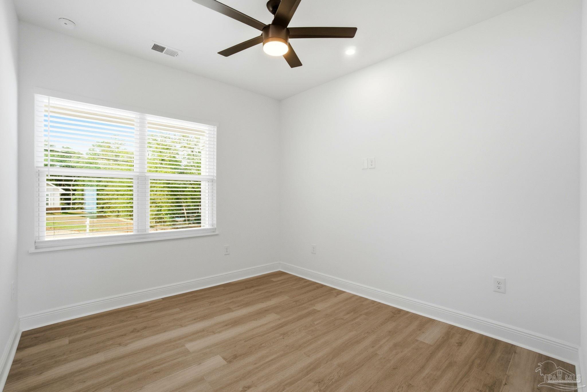 5712 Riviera Drive Milton, FL 32583 - Photo 29 of 41 a view of a room with wooden floor and windows