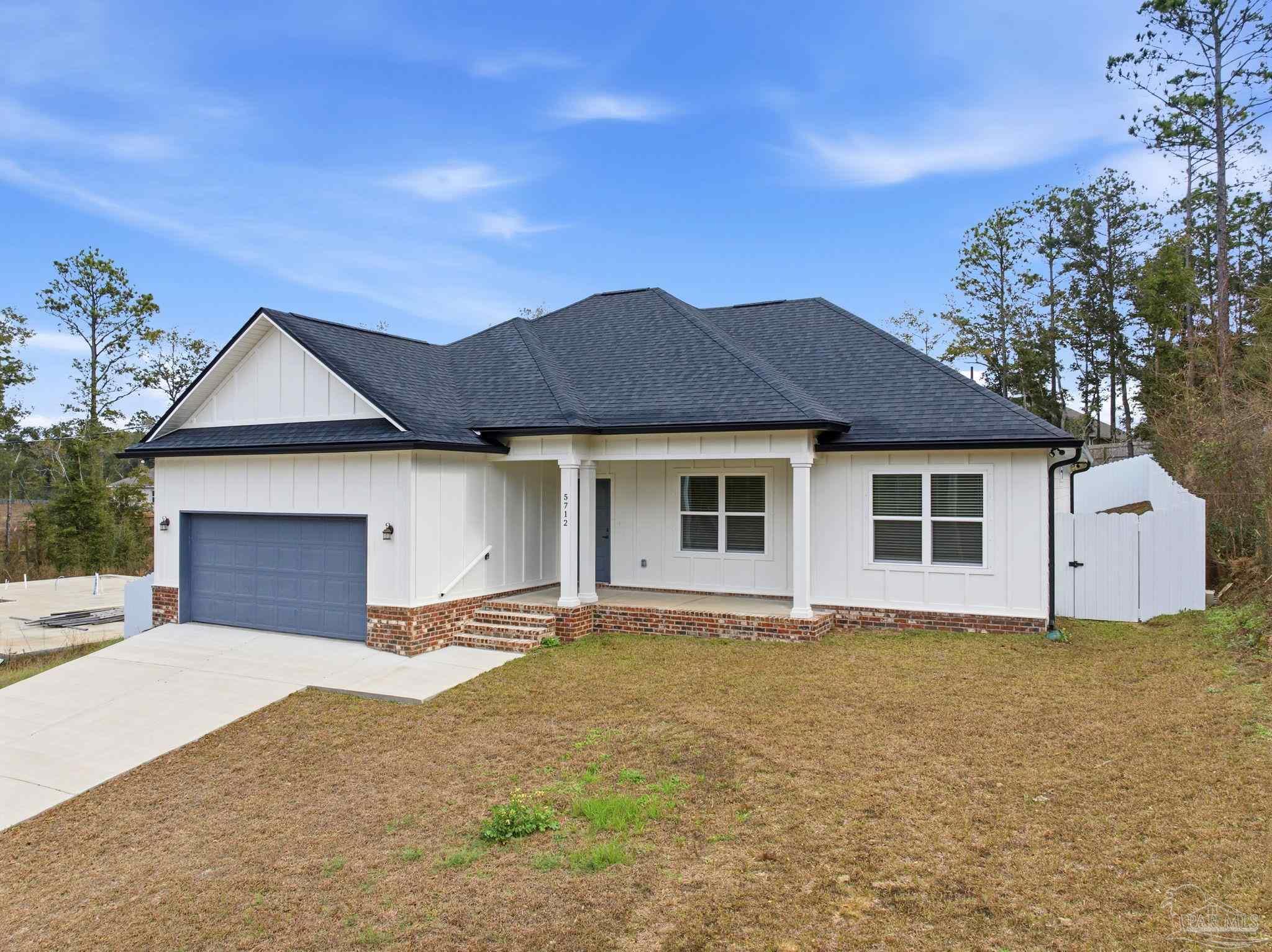 5712 Riviera Drive Milton, FL 32583 - Photo 4 of 41 a front view of a house with a yard and garage