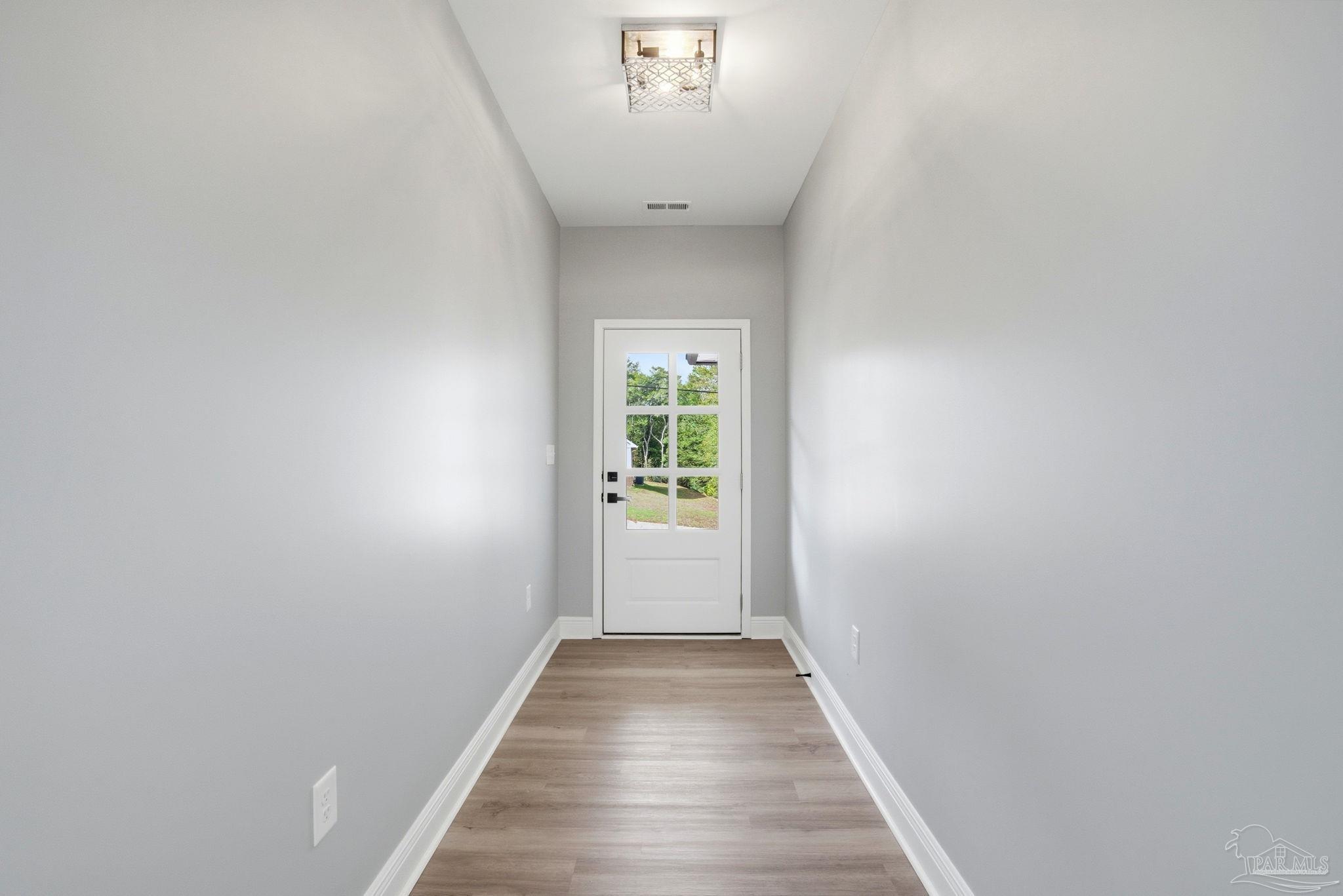 5712 Riviera Drive Milton, FL 32583 - Photo 7 of 41 a view of a hallway with wooden floor