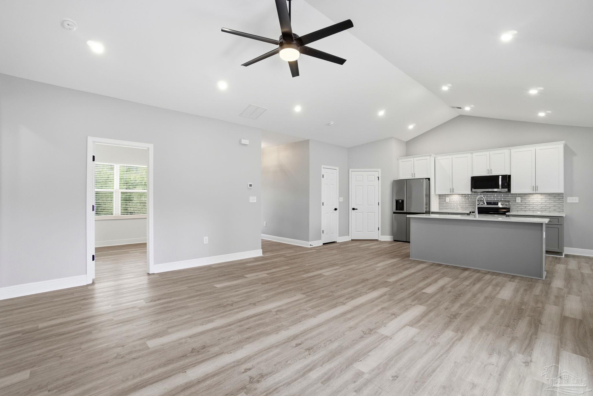 5712 Riviera Drive Milton, FL 32583 - Photo 9 of 41 a view of kitchen with wooden floor and window