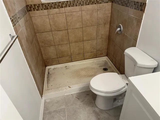 a white toilet sitting next to a bath tub