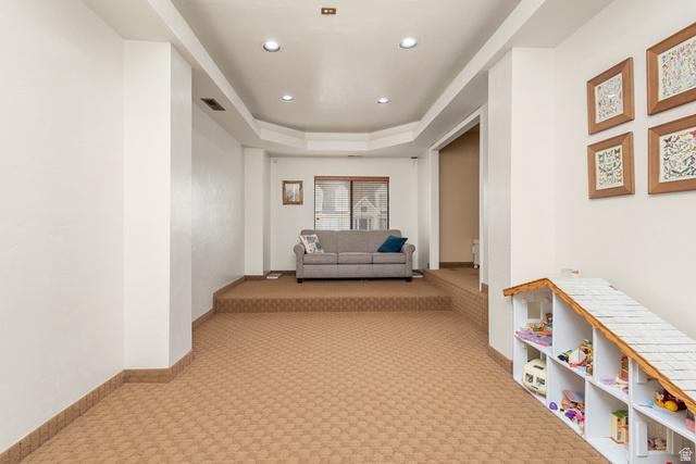 892 Cambridge Drive St. George, UT 84770 - Photo 13 of 65 Recessed lighting illuminates this room, featuring a built-in shelving unit, patterned carpeting, and a raised platform area