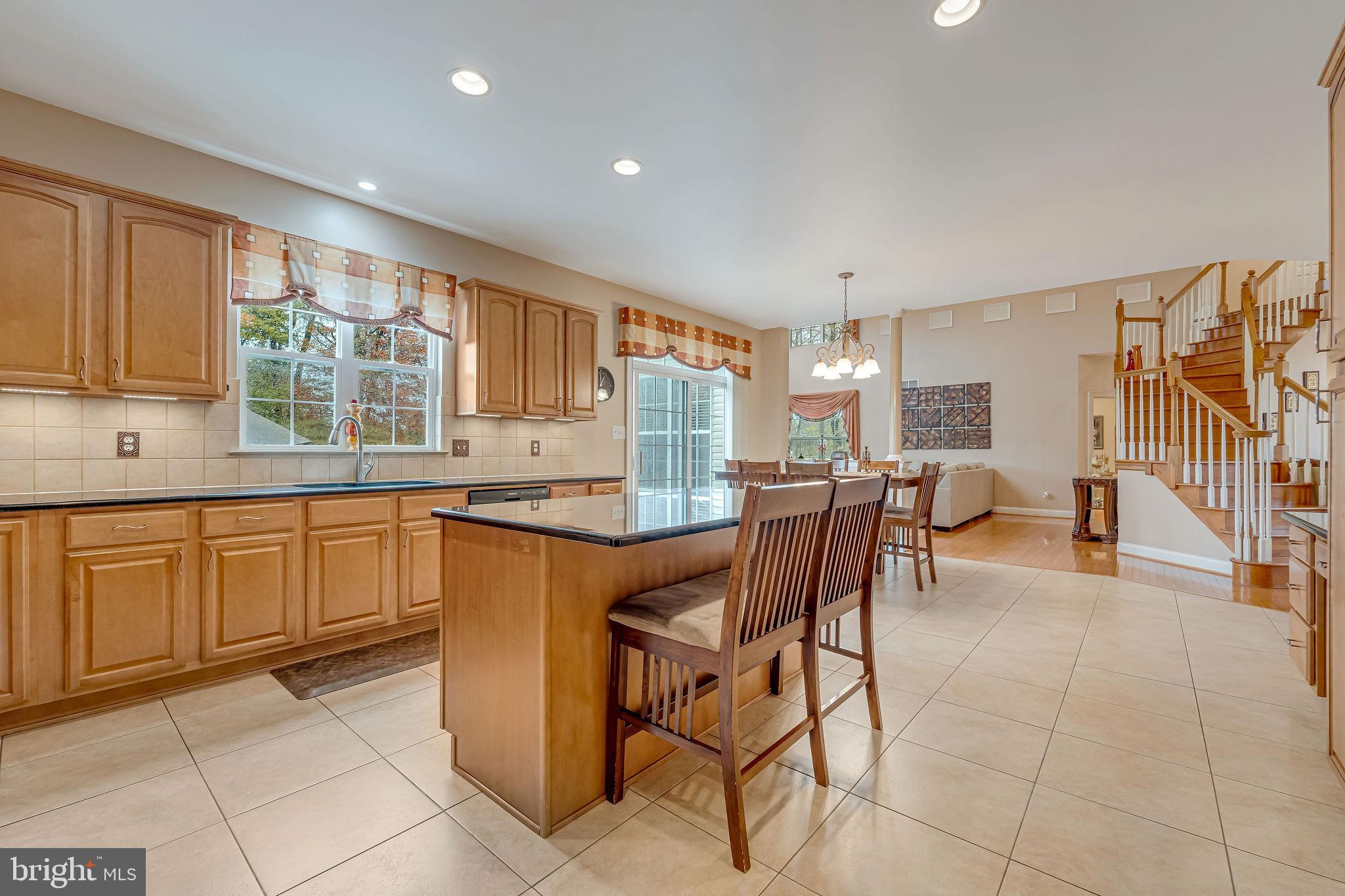 2 Lansbrook Court Sewell, NJ 08080 - Photo 25 of 44 a kitchen with granite countertop a stove a sink a dining table and chairs