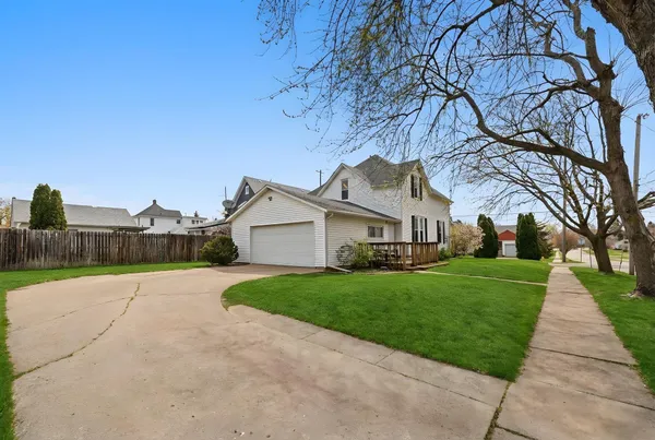 a view of a house with backyard and a tree