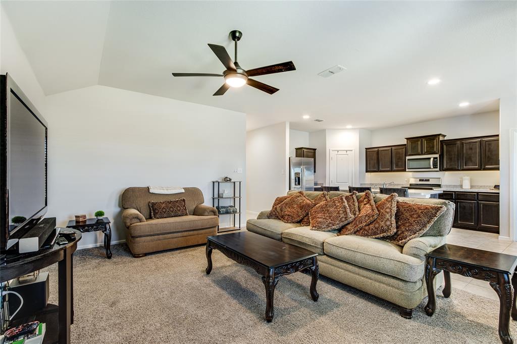 16516 Portage Street Justin, TX 76247 - Photo 12 of 29 a living room with furniture and a flat screen tv with kitchen view