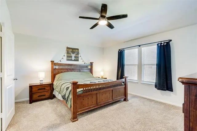 a bedroom with a bed and a ceiling fan