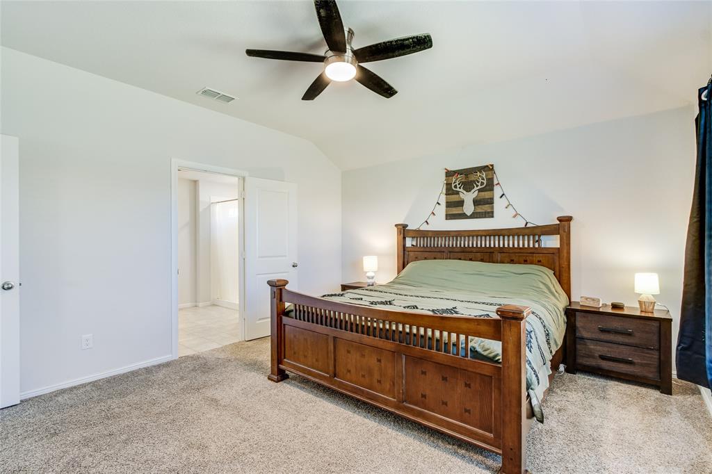 16516 Portage Street Justin, TX 76247 - Photo 16 of 29 a bedroom with a bed and a chandelier