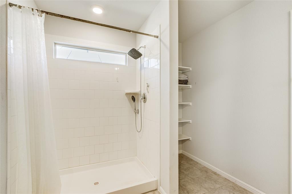 16516 Portage Street Justin, TX 76247 - Photo 19 of 29 a bathroom with a glass shower door