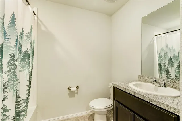 a bathroom with a granite countertop sink a toilet and a mirror