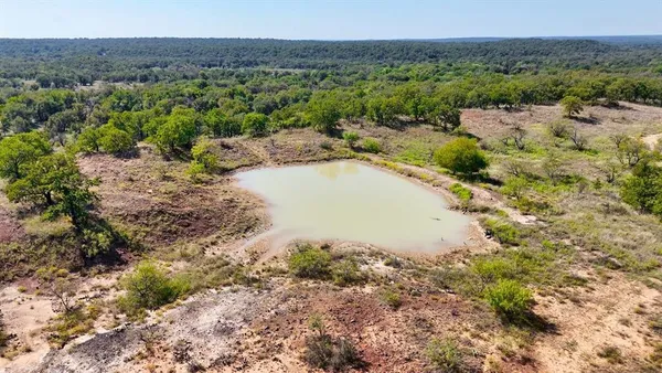 a view of a lake with beach and green space