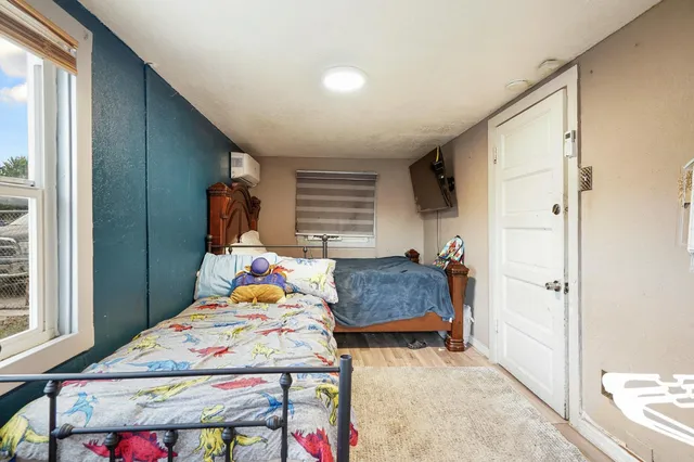 a bedroom with a bed and wooden floor