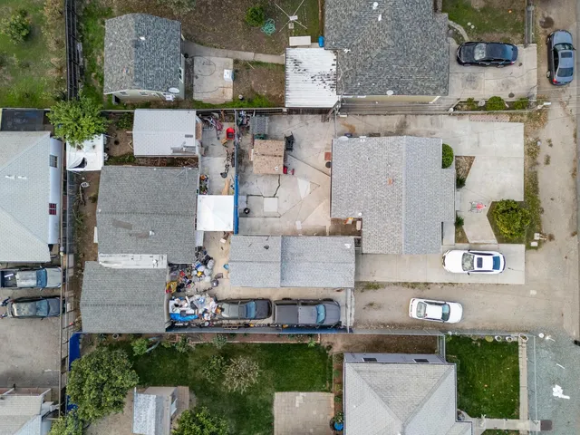an aerial view of residential houses with outdoor space and parking