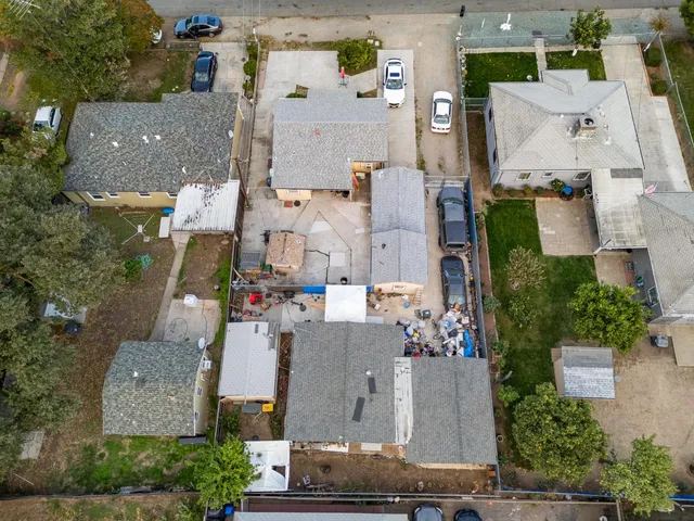 an aerial view of residential houses with outdoor space and parking