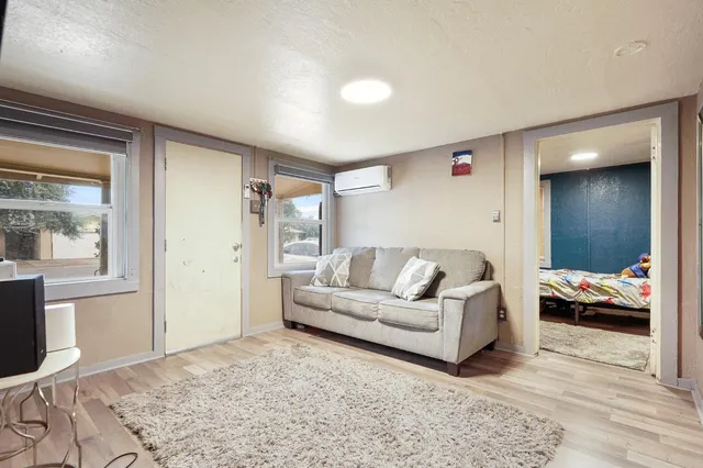 a living room with furniture and a large mirror with wooden floor