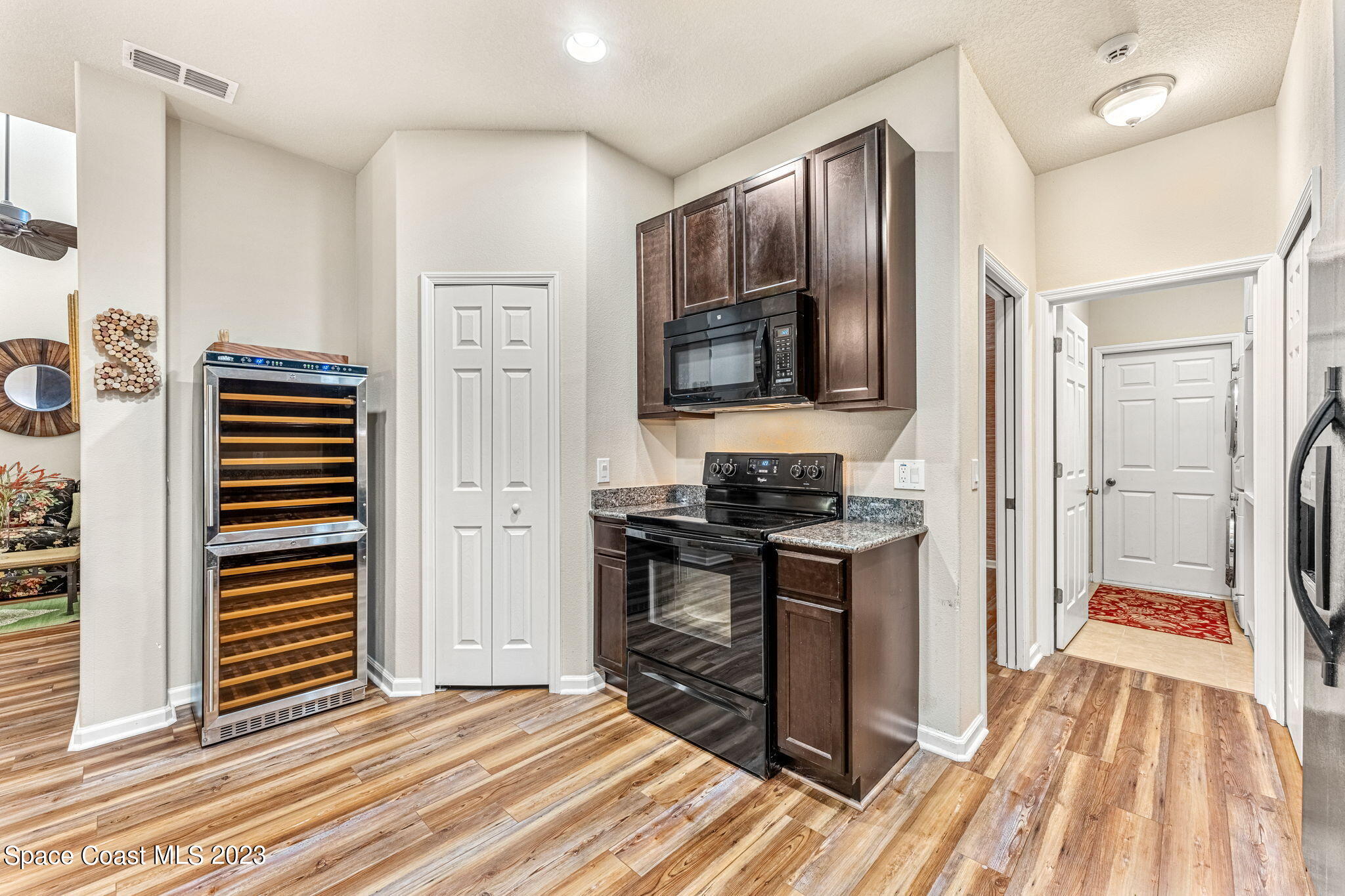 3310 Titanic Circle Indialantic, FL 32903 - Photo 6 of 25 a kitchen view with wooden floor stainless steel appliances and cabinets