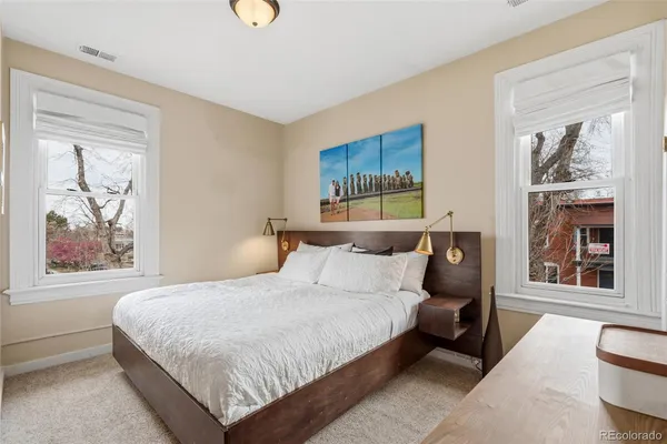 a bedroom with a bed and a painting on the wall