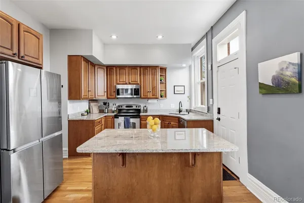 a large kitchen with wooden floors and stainless steel appliances