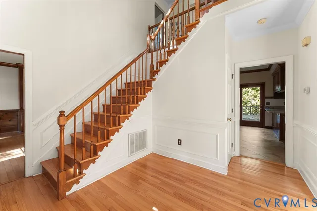 a view of staircase with wooden floor and a chandelier