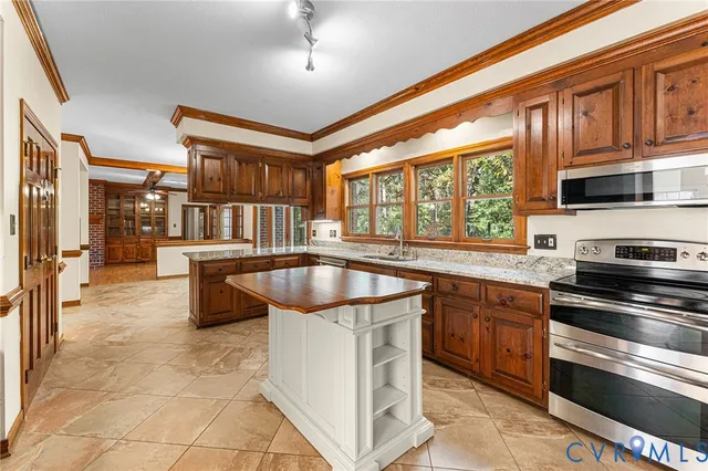 a kitchen with stainless steel appliances granite countertop a stove top oven a sink dishwasher a dining table and chairs with wooden floor