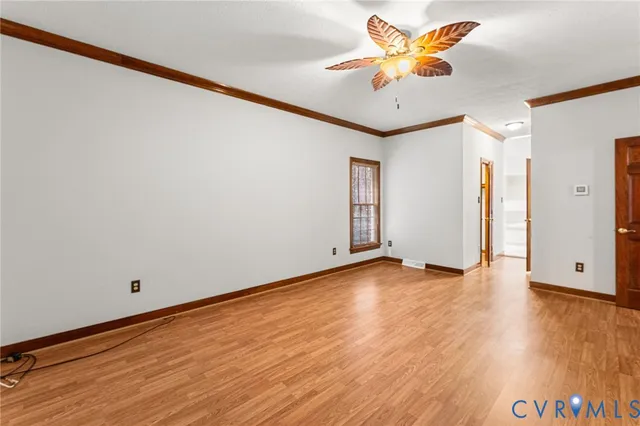 a view of an empty room with window and a ceiling fan