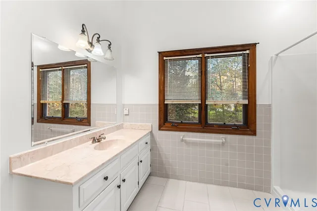 a bathroom with a sink mirror and a bathtub next to a window