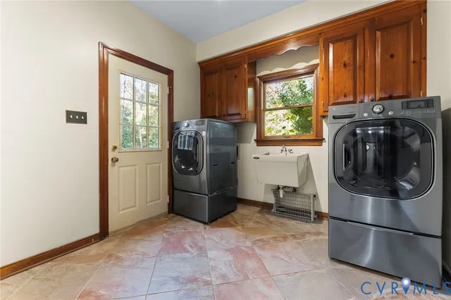 a utility room with fridge dryer and washer