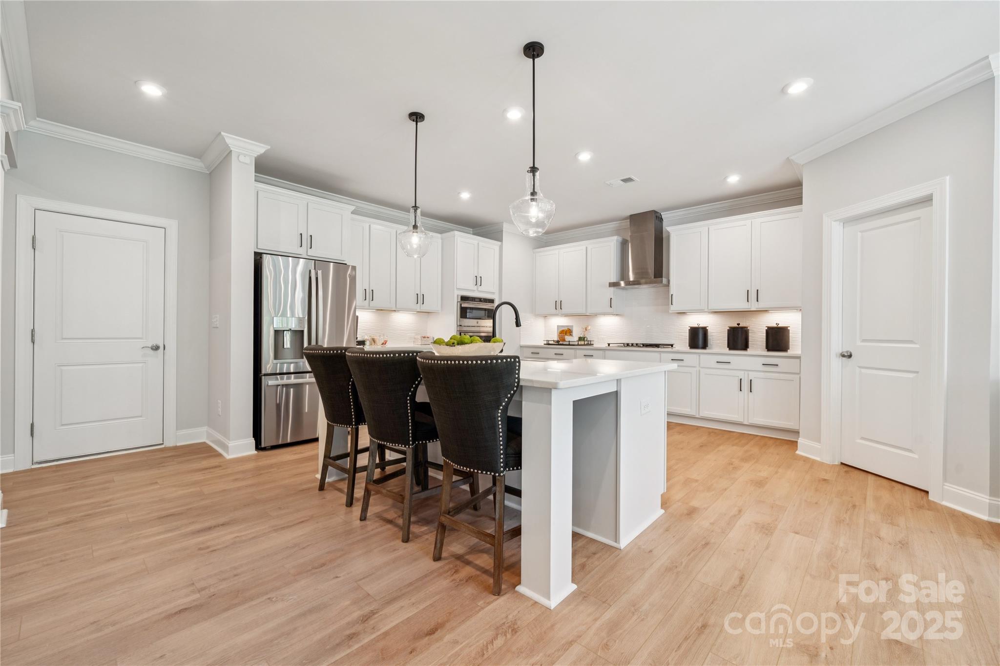 136 Balboa Street Matthews, NC 28104 - Photo 13 of 47 a kitchen with stainless steel appliances kitchen island granite countertop a refrigerator a stove a sink and a dining table with wooden floor